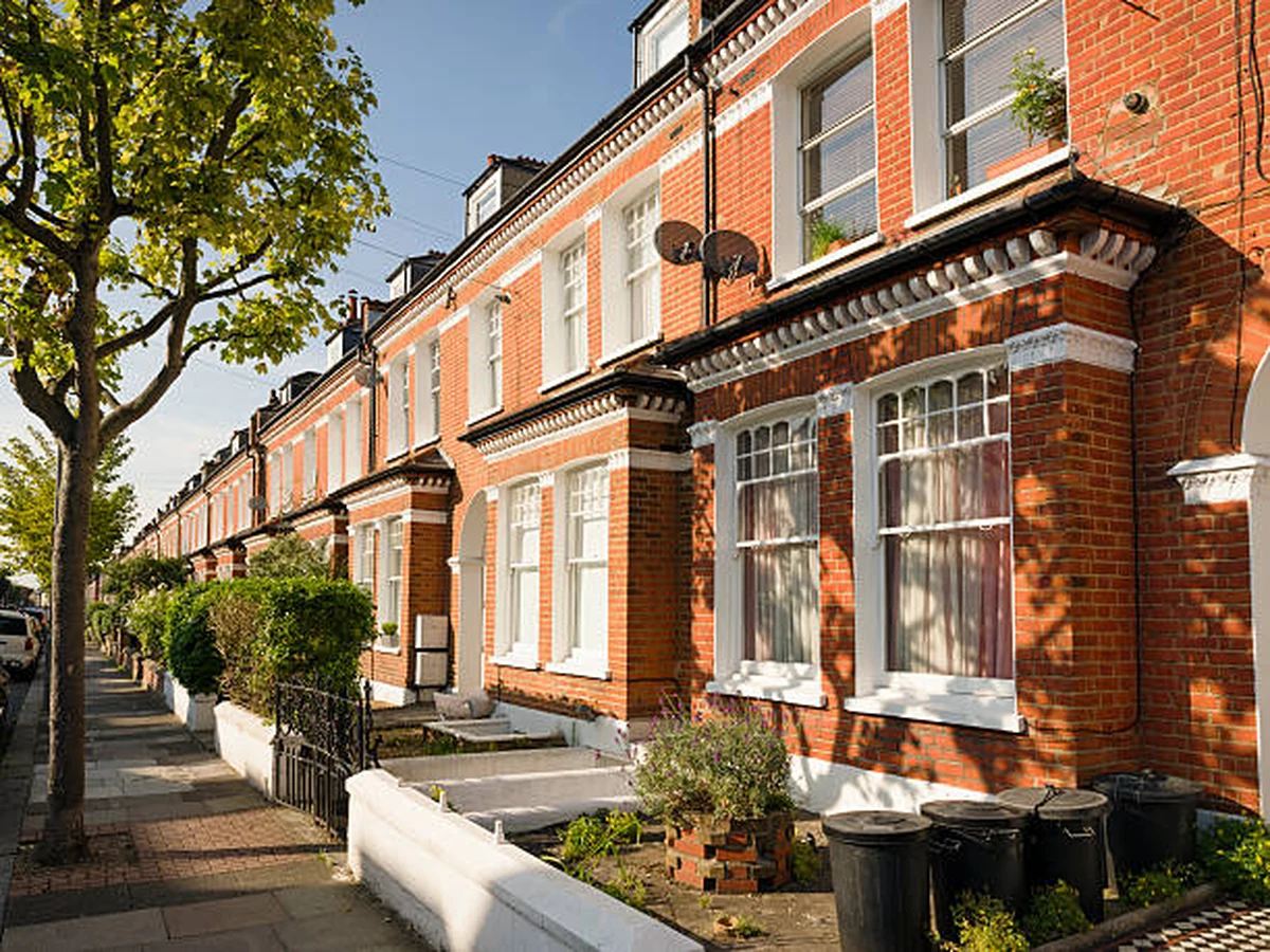 Row of red brick Victorian terraced houses with white window frames