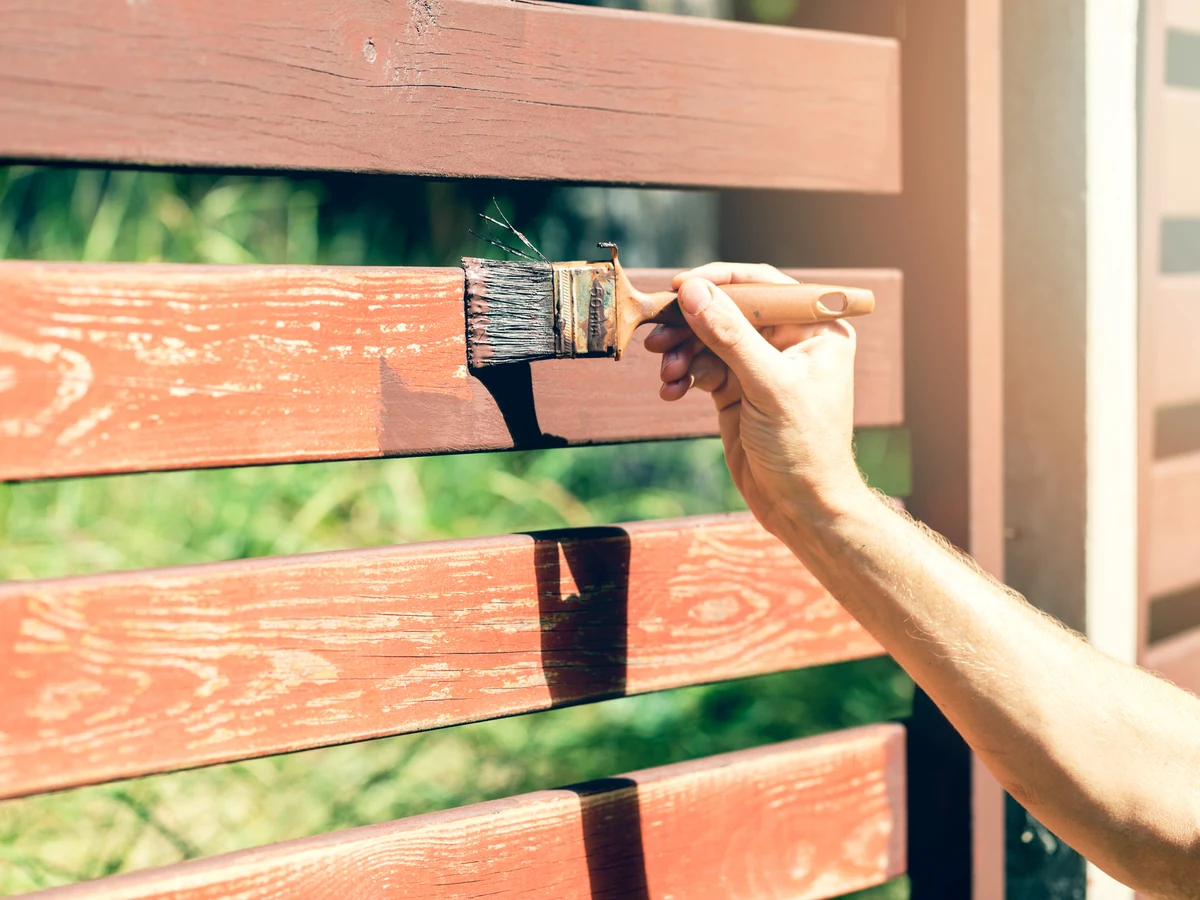 fence-painting-hand-applying-dark-bridgend-decorators Hand applying dark exterior paint to wood in Bridgend by Bridgend Decorators