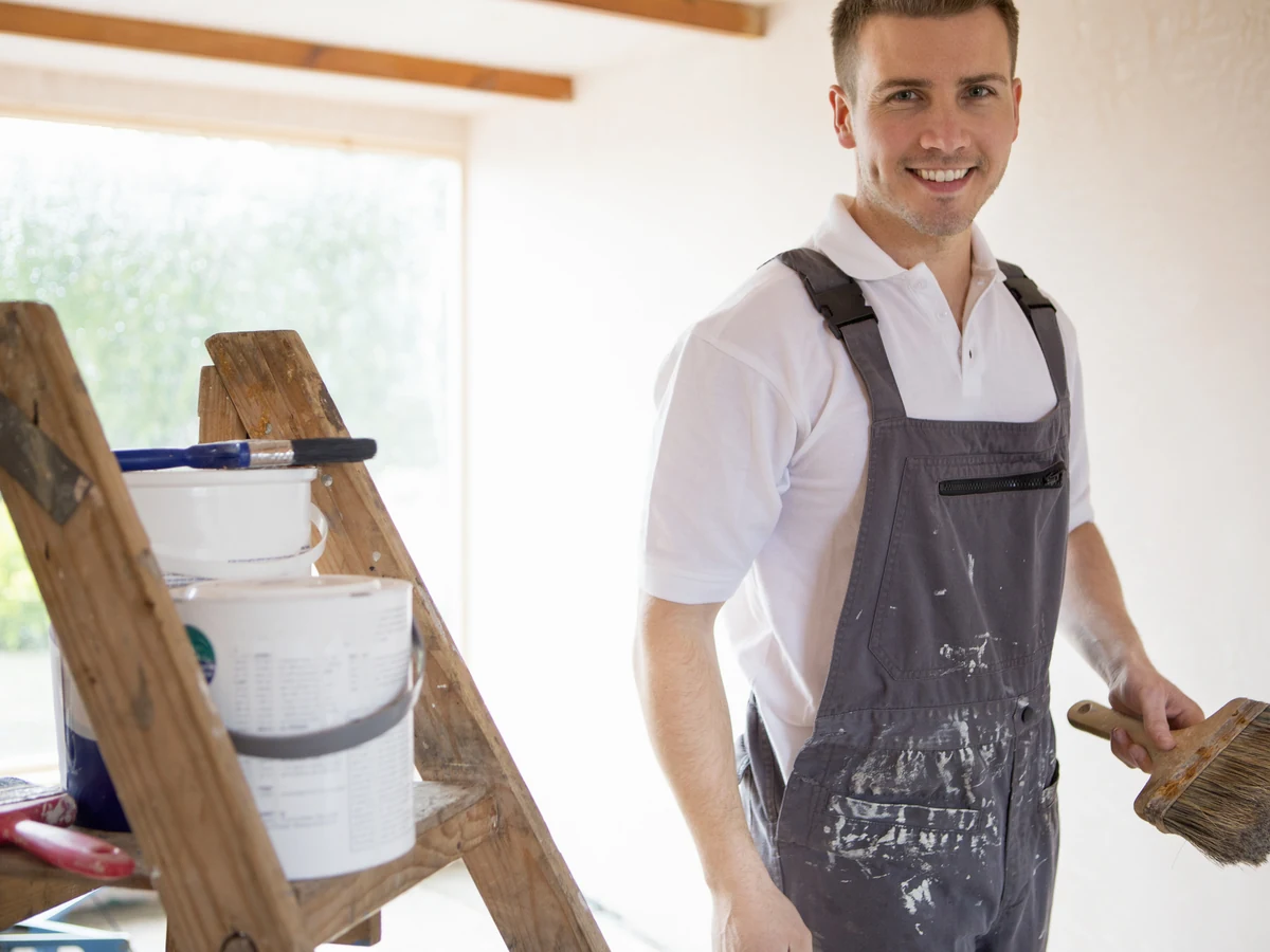 painting-decorating-decorator-brush-ladder-bridgend-decorators Professional decorator on ladder painting exterior in Bridgend by Bridgend Decorators